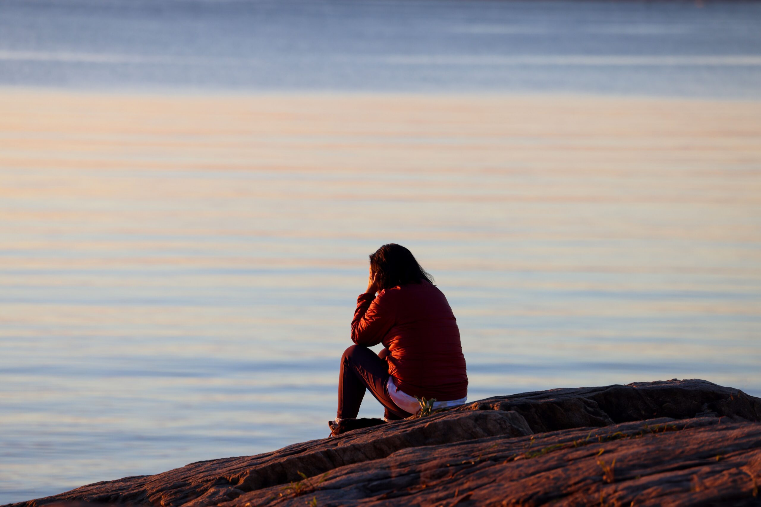 person sitting down staring off in grief