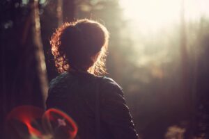 A person sitting outside in nature considering whether they need therapy